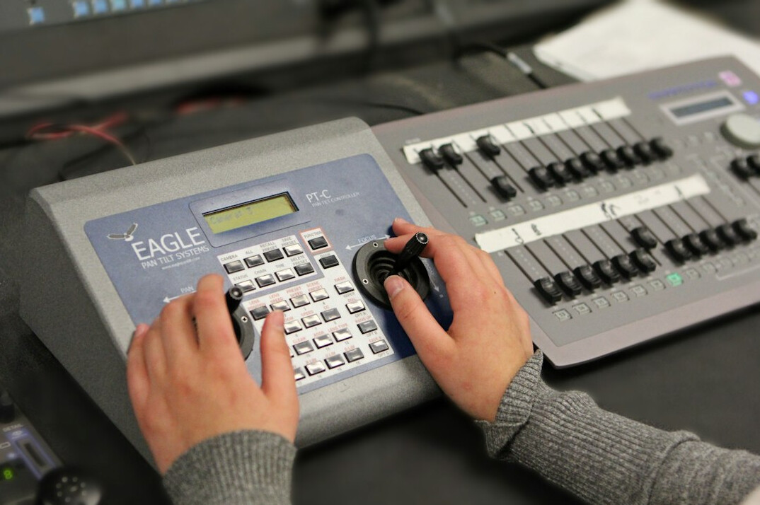 British male broadcast instructor teaching in a control room